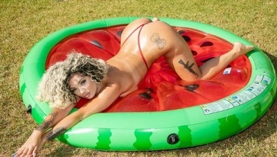 Evelina Chivu on a pool ring while only wearing a red thong.